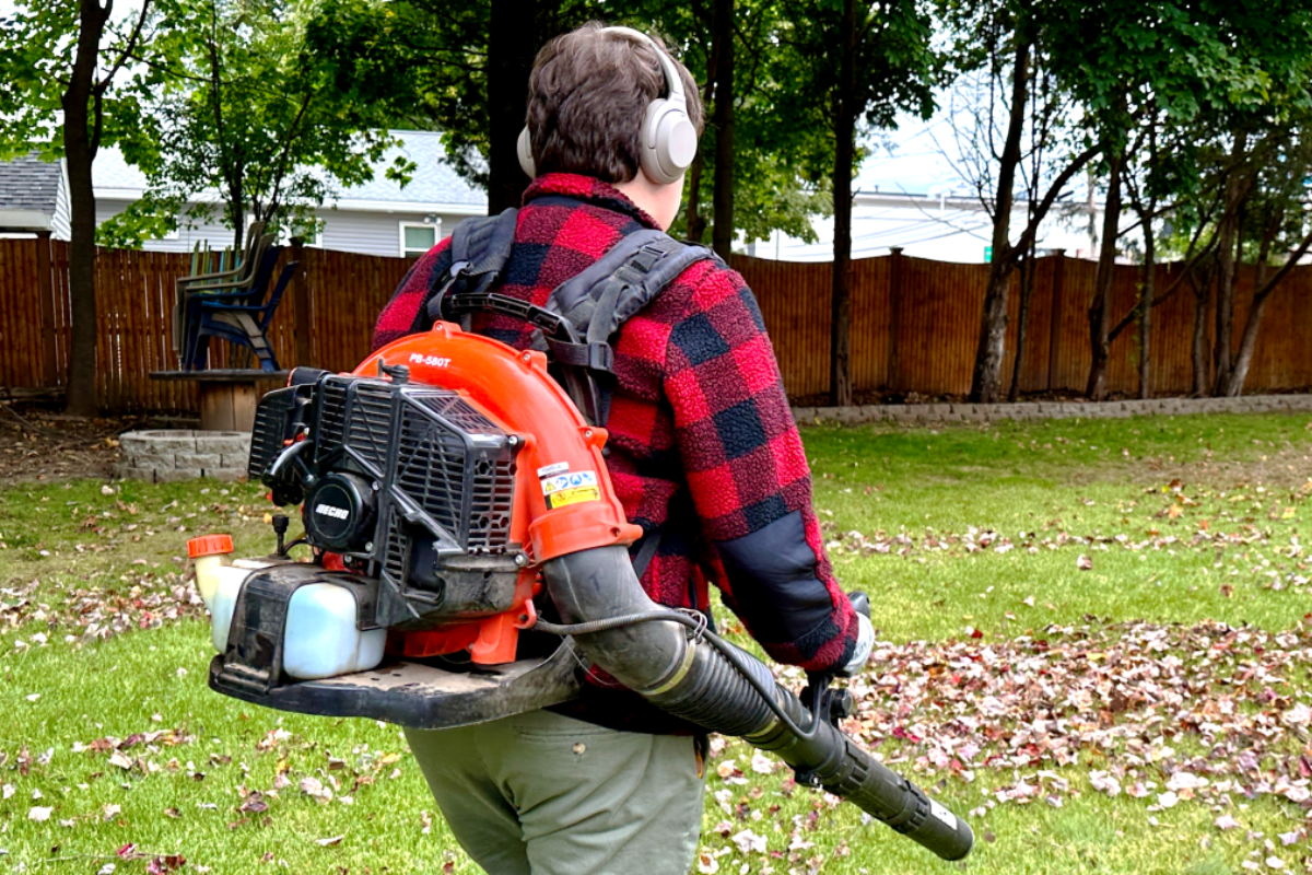 Illustrated campaign image of a gas-powered leaf blower in use